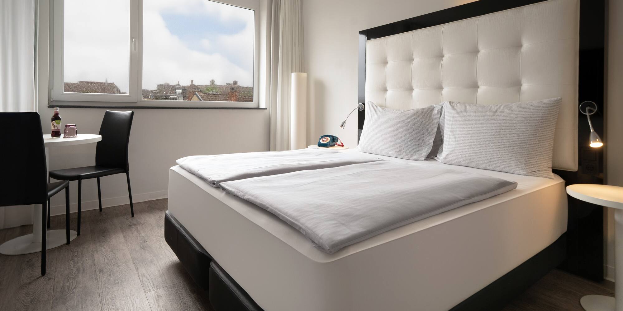 a bed with white sheets and a black headboard