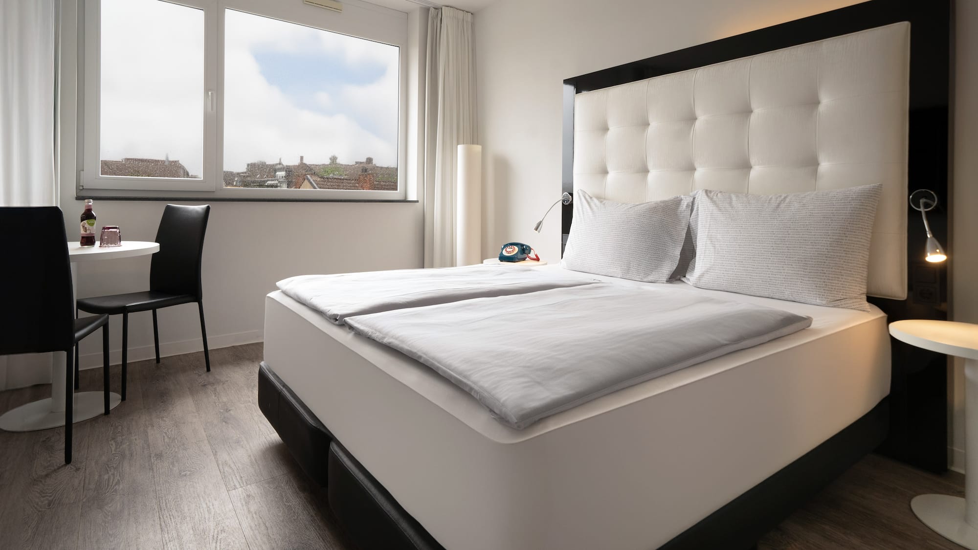 a bed with white sheets and a black headboard