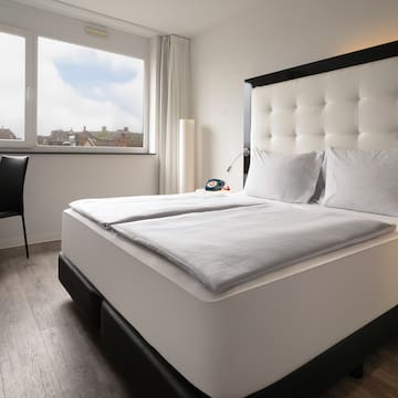 a bed with white sheets and a black headboard