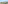 Scenic balcony view of a sunny town, green trees, and distant mountains.