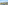 Scenic balcony view of a sunny town, green trees, and distant mountains.