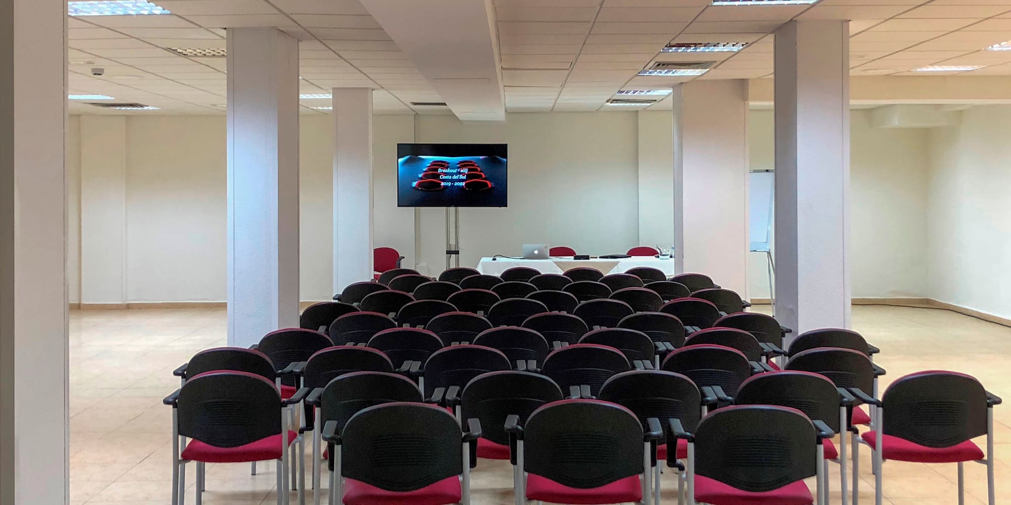 a room with rows of chairs and a television