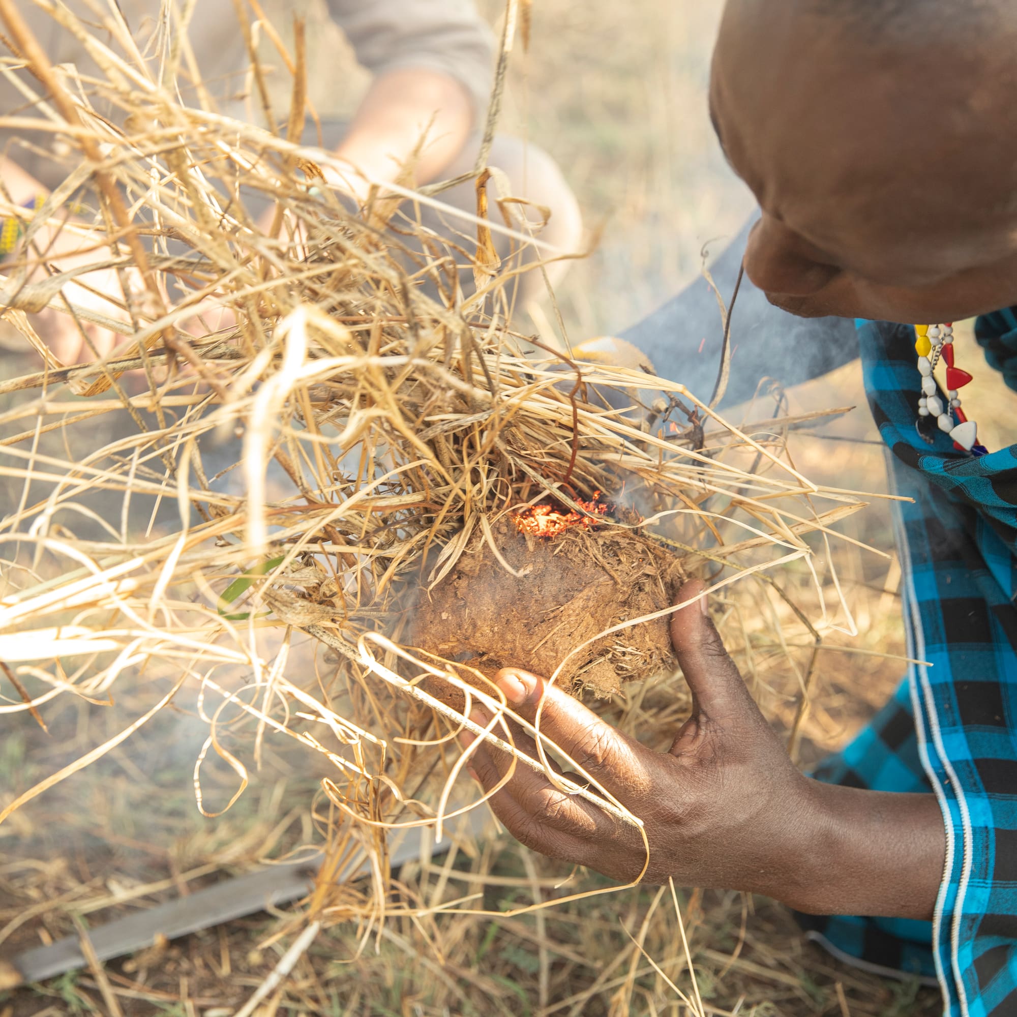 a man holding a small object with sticks