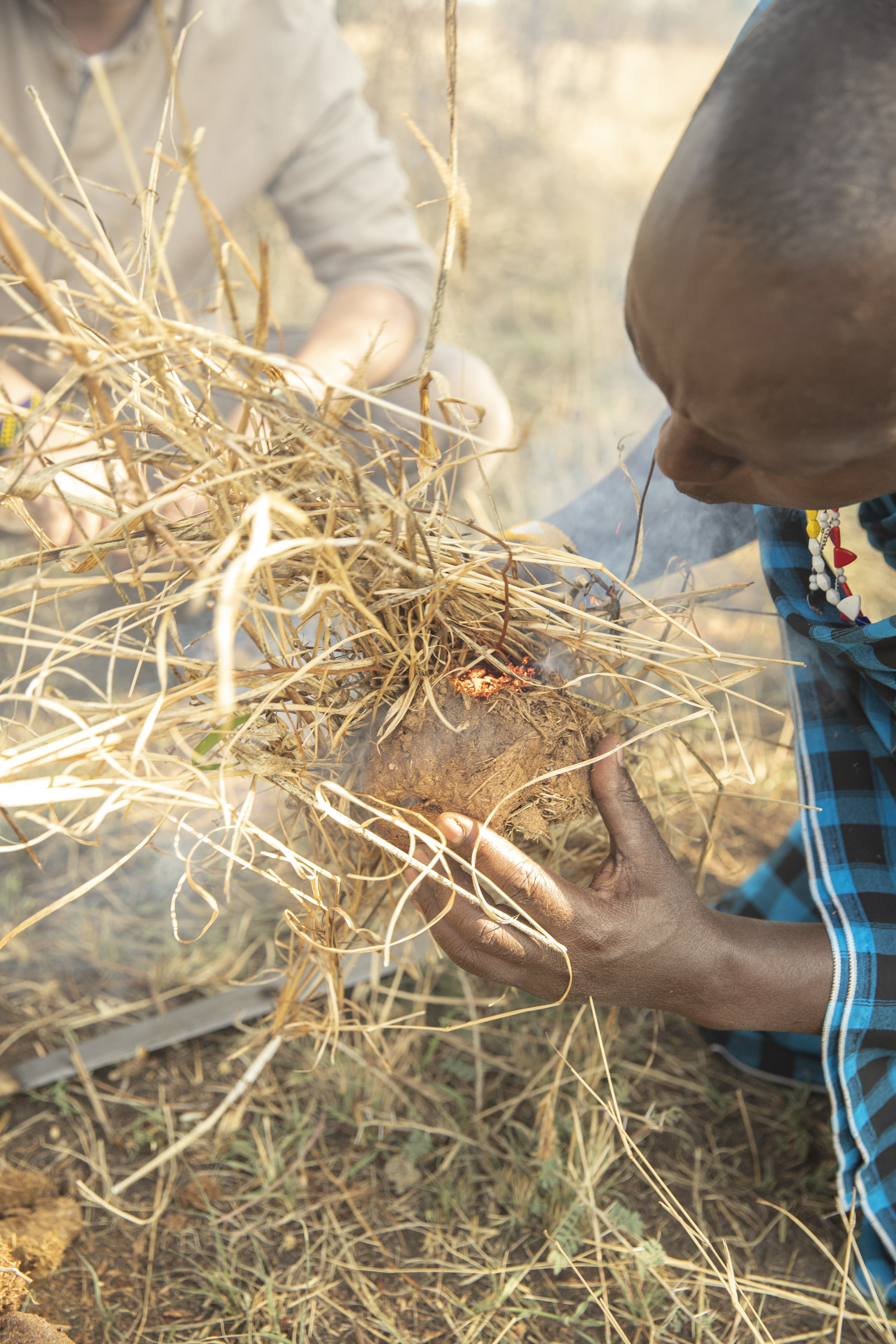 a man holding a small object with sticks