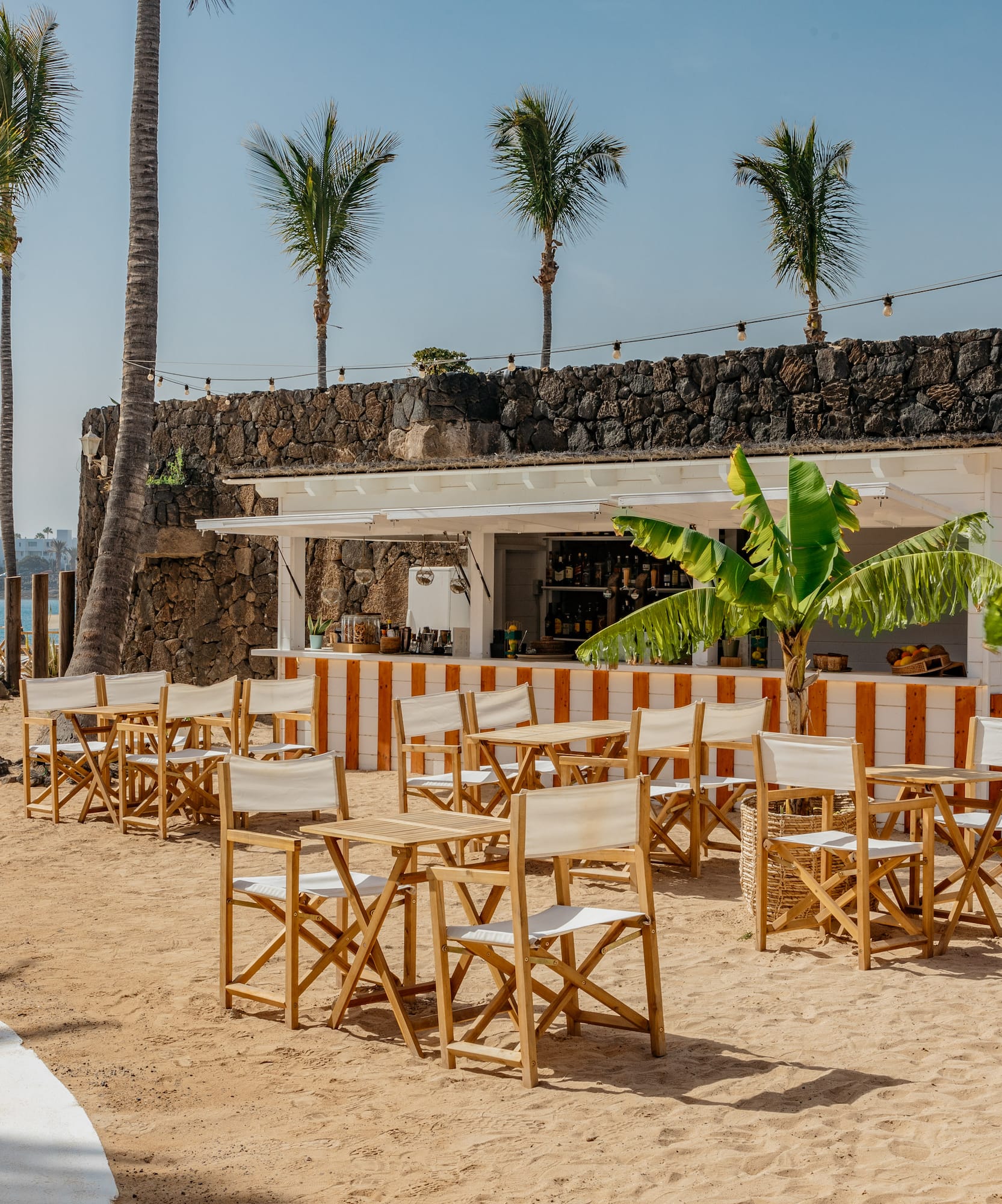 a group of chairs and tables on a beach