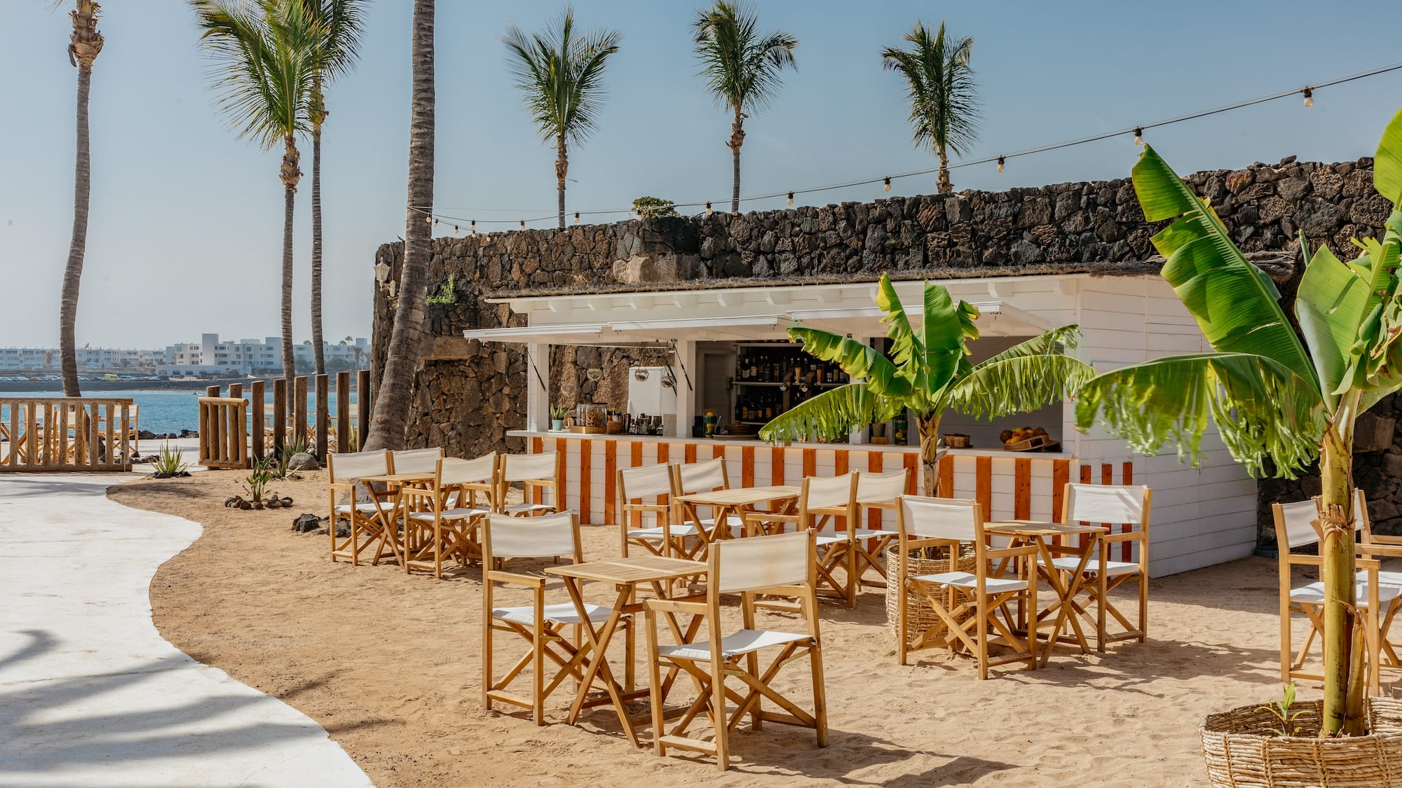 a group of chairs and tables on a beach