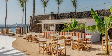 a group of chairs and tables on a beach