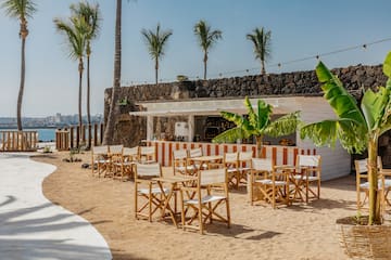 a group of chairs and tables on a beach