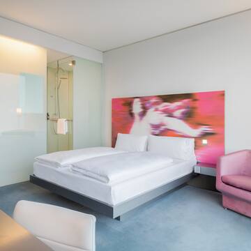 a room with a bed and a pink chair