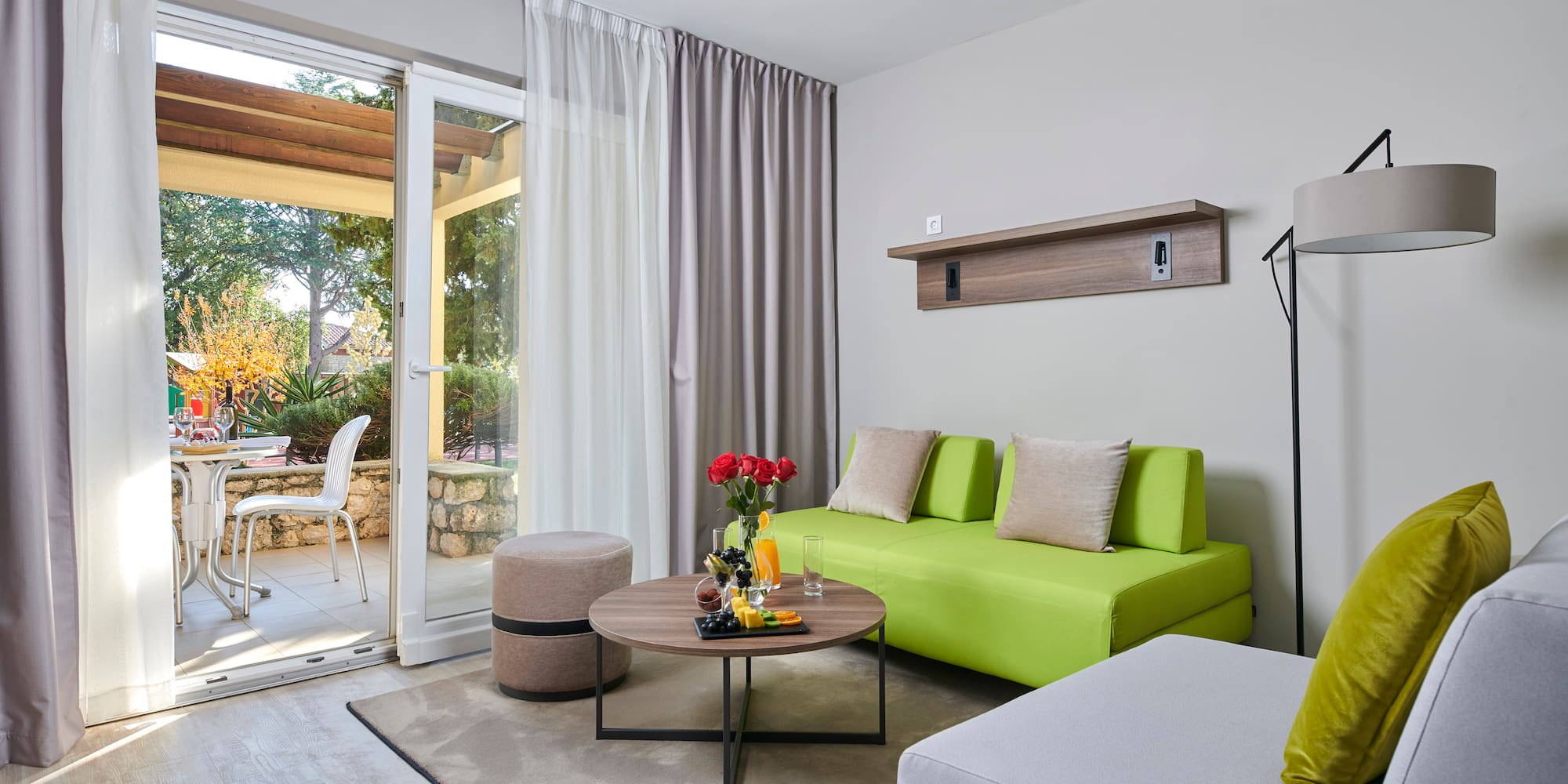 a living room with a green couch and a glass door