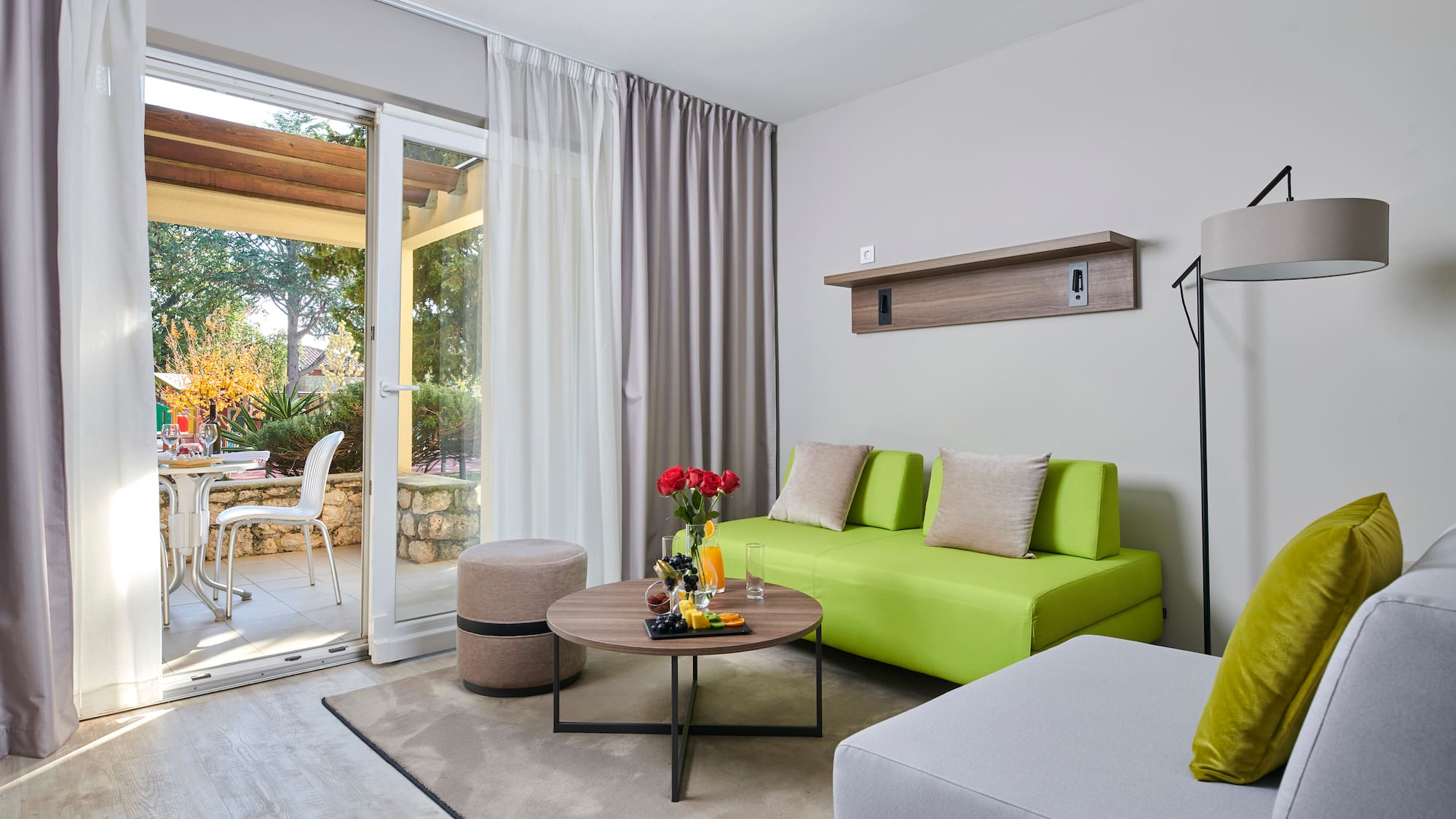 a living room with a green couch and a glass door
