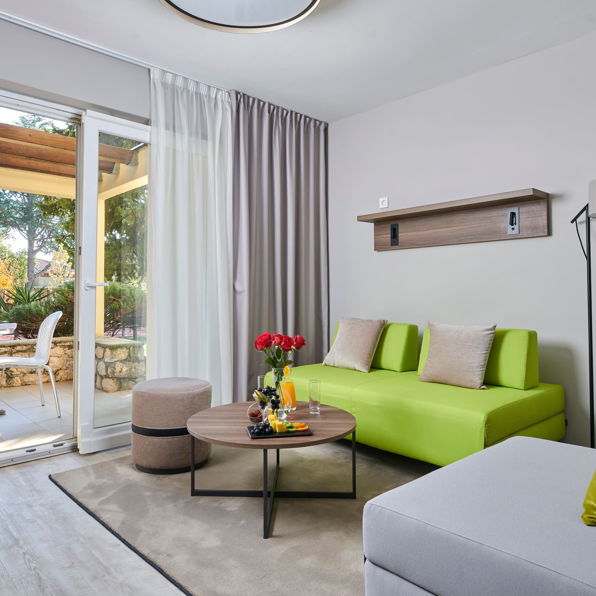a living room with a green couch and a glass door