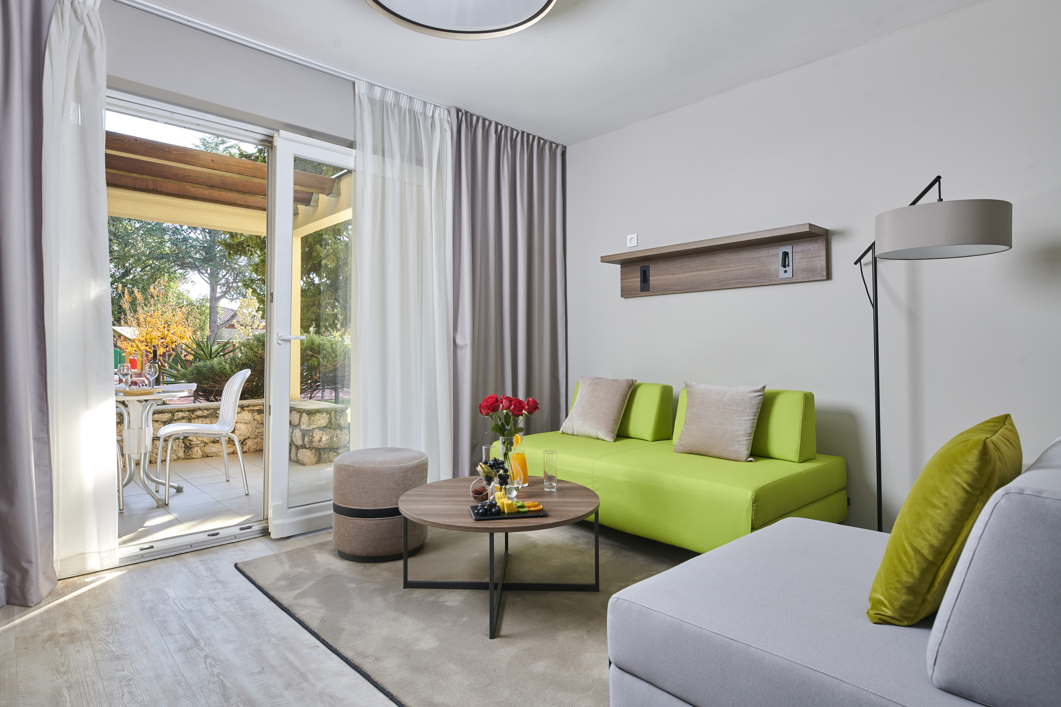 a living room with a green couch and a glass door