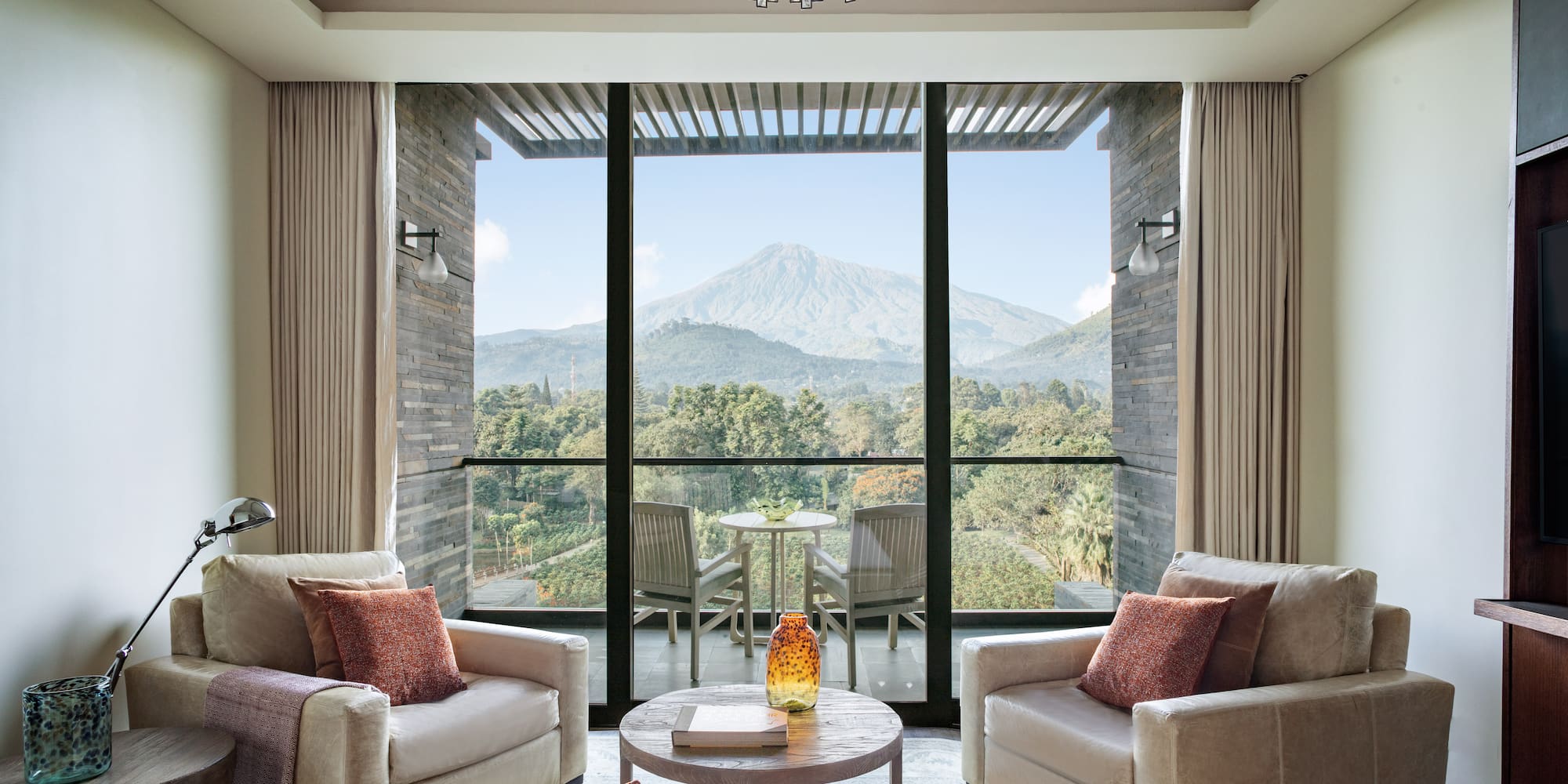 a living room with a view of a mountain and trees