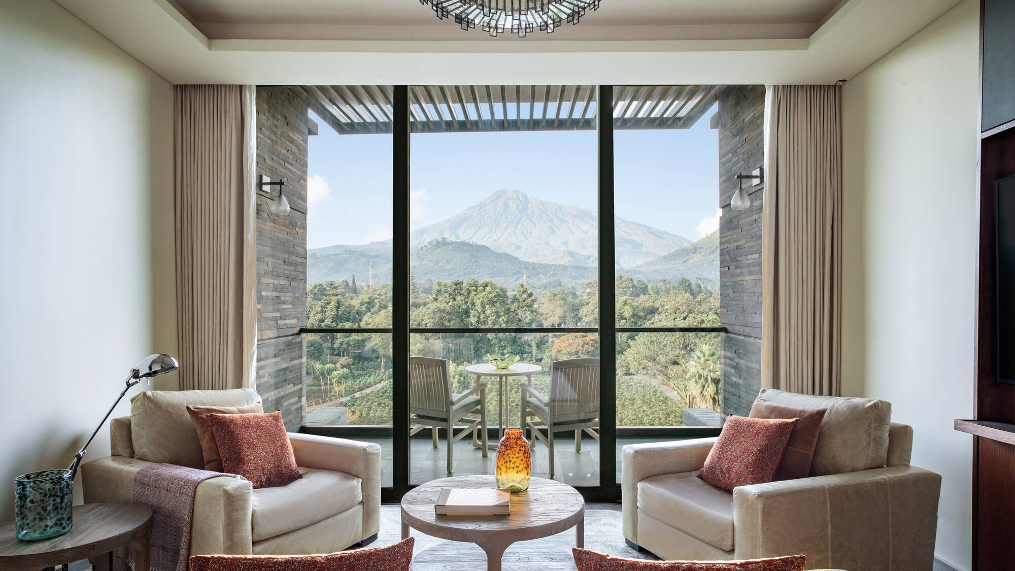a living room with a view of a mountain and trees