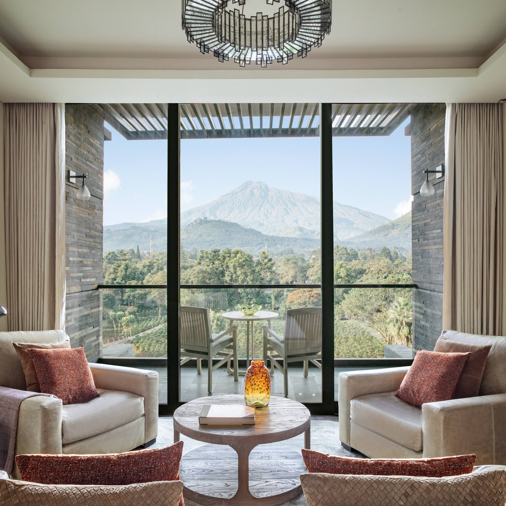 a living room with a view of a mountain and trees