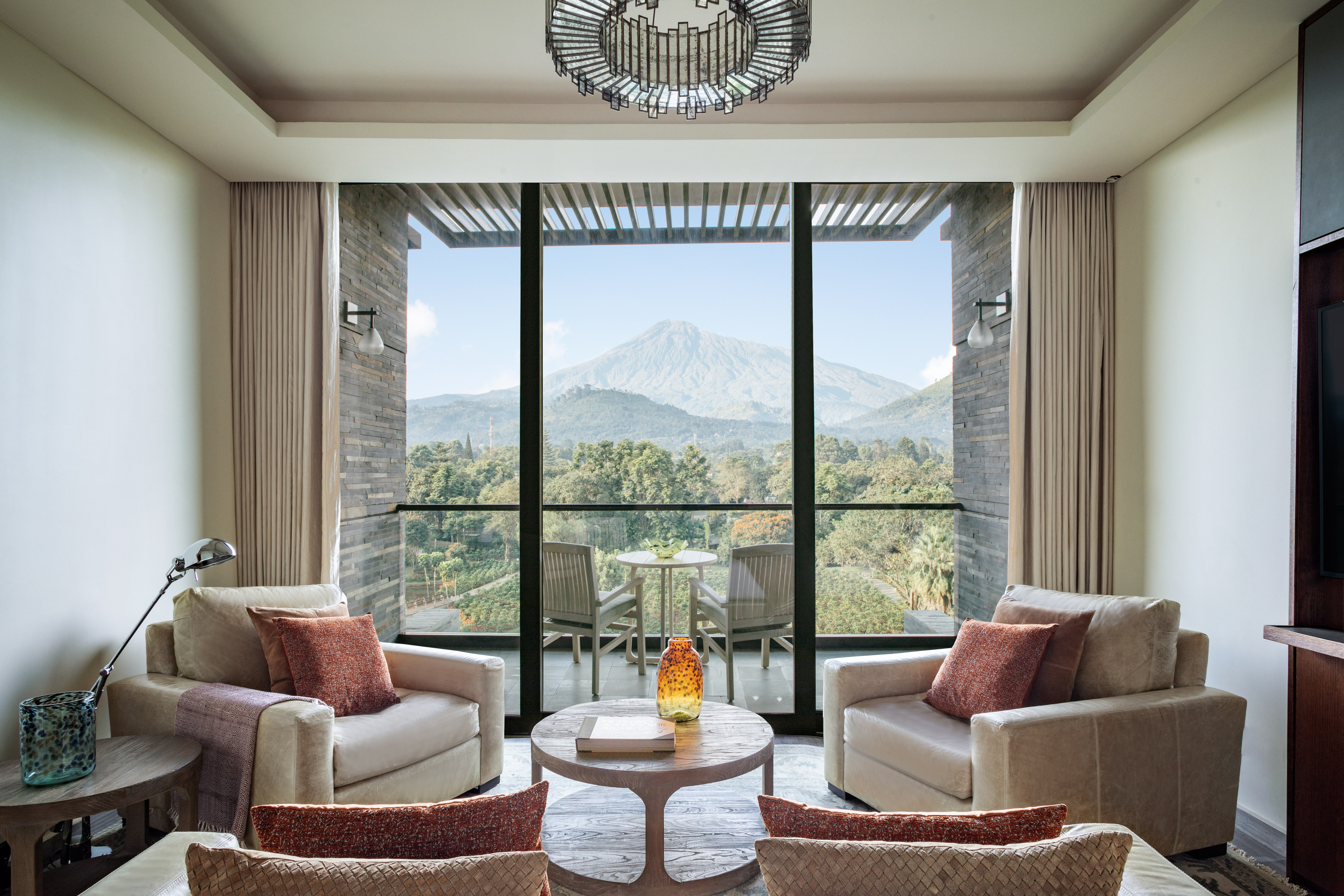 Luxury hotel suite living room with mountain view balcony.