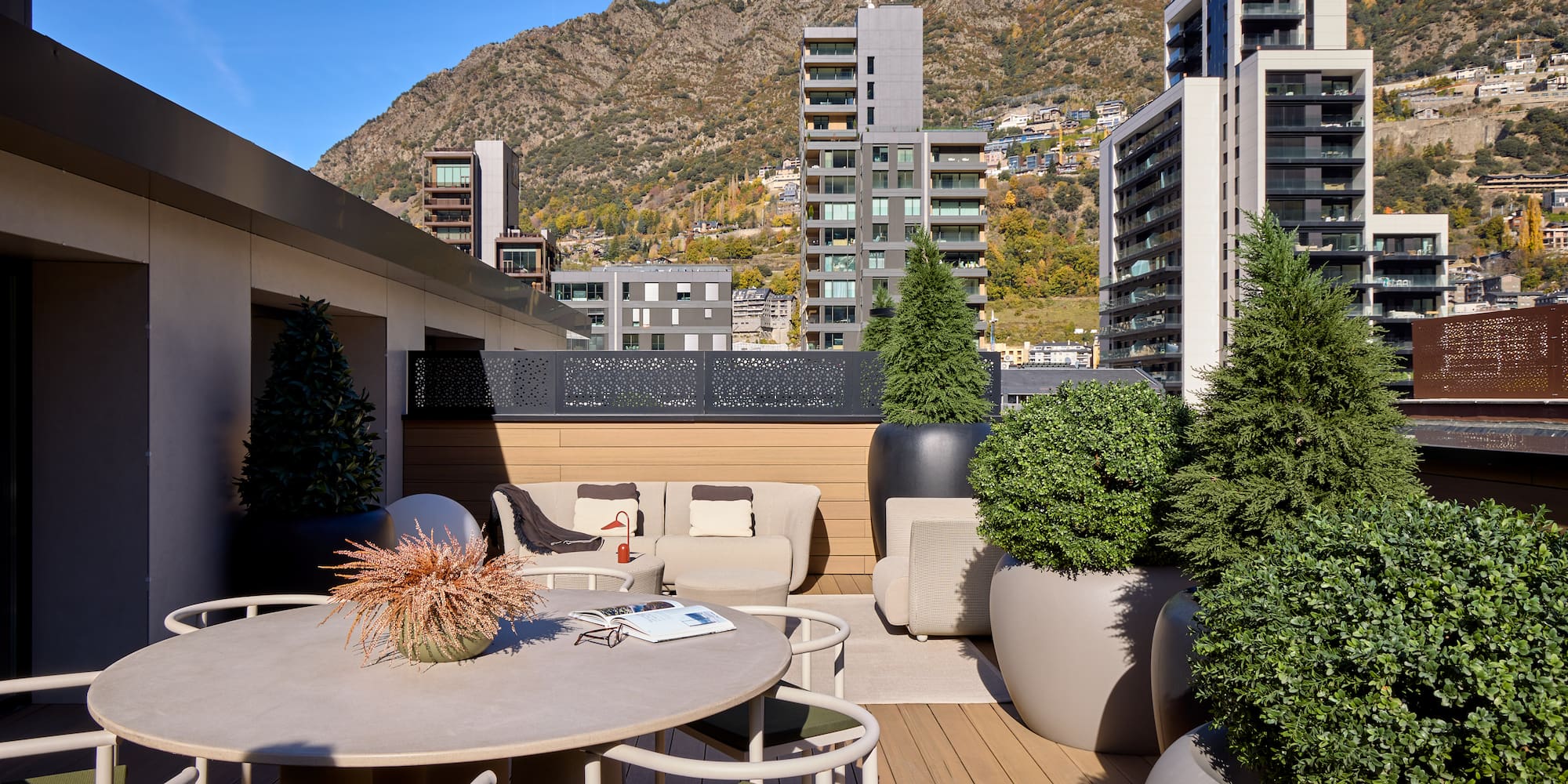 a patio with a table and chairs and trees in pots