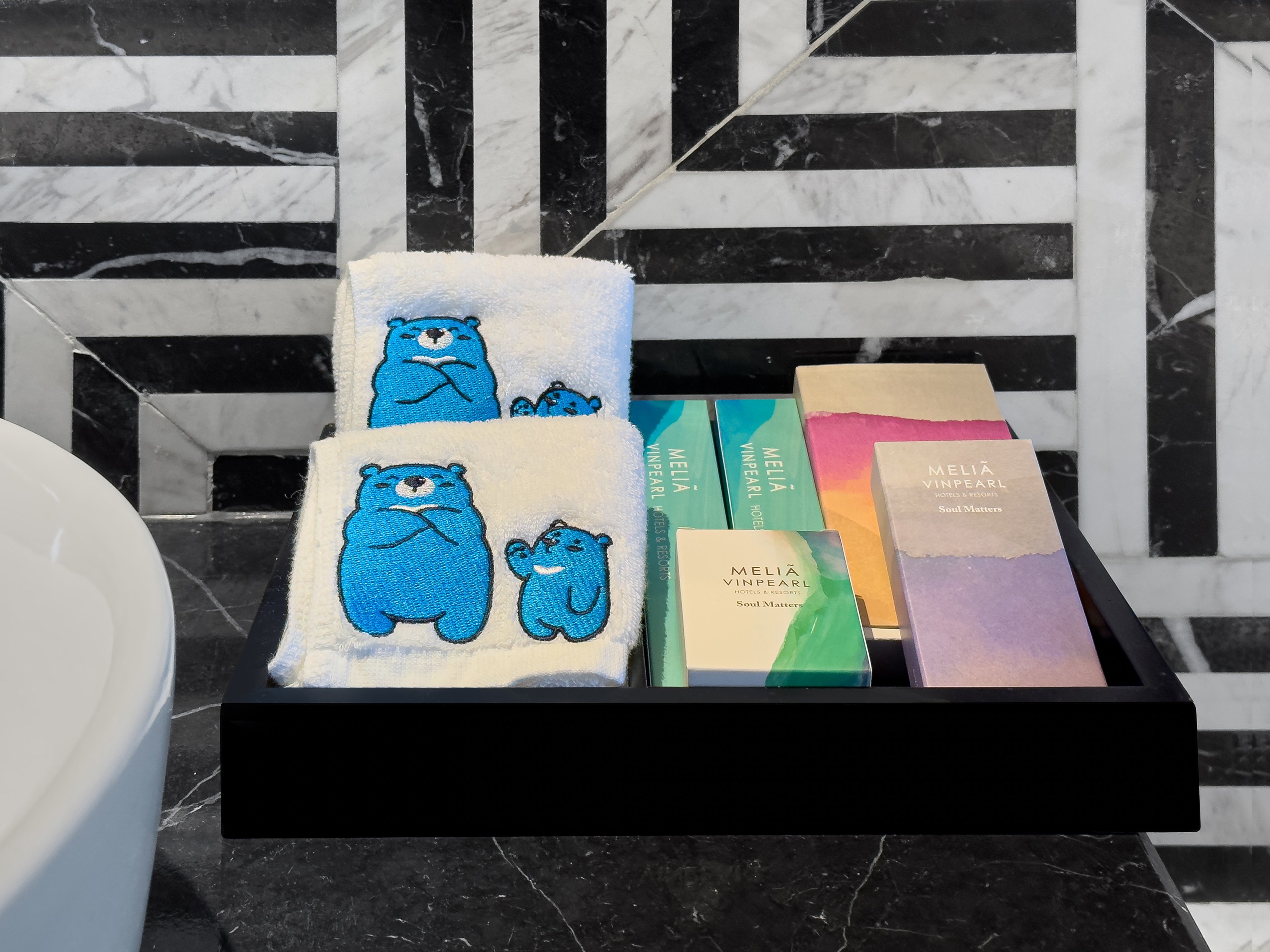 Melia Vinpearl hotel amenities, bear embroidered towels, marble bathroom.