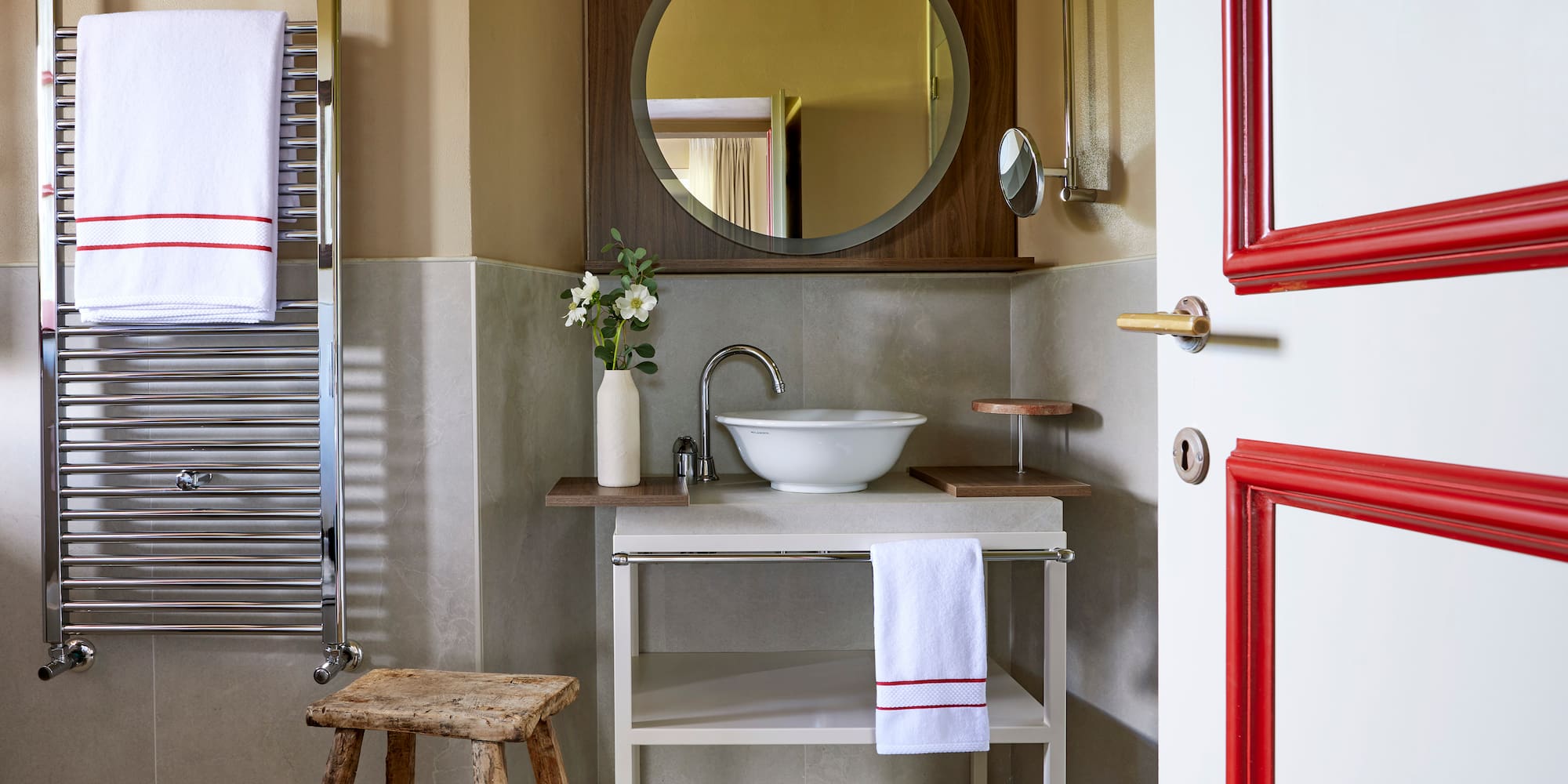 a bathroom with a round mirror and sink