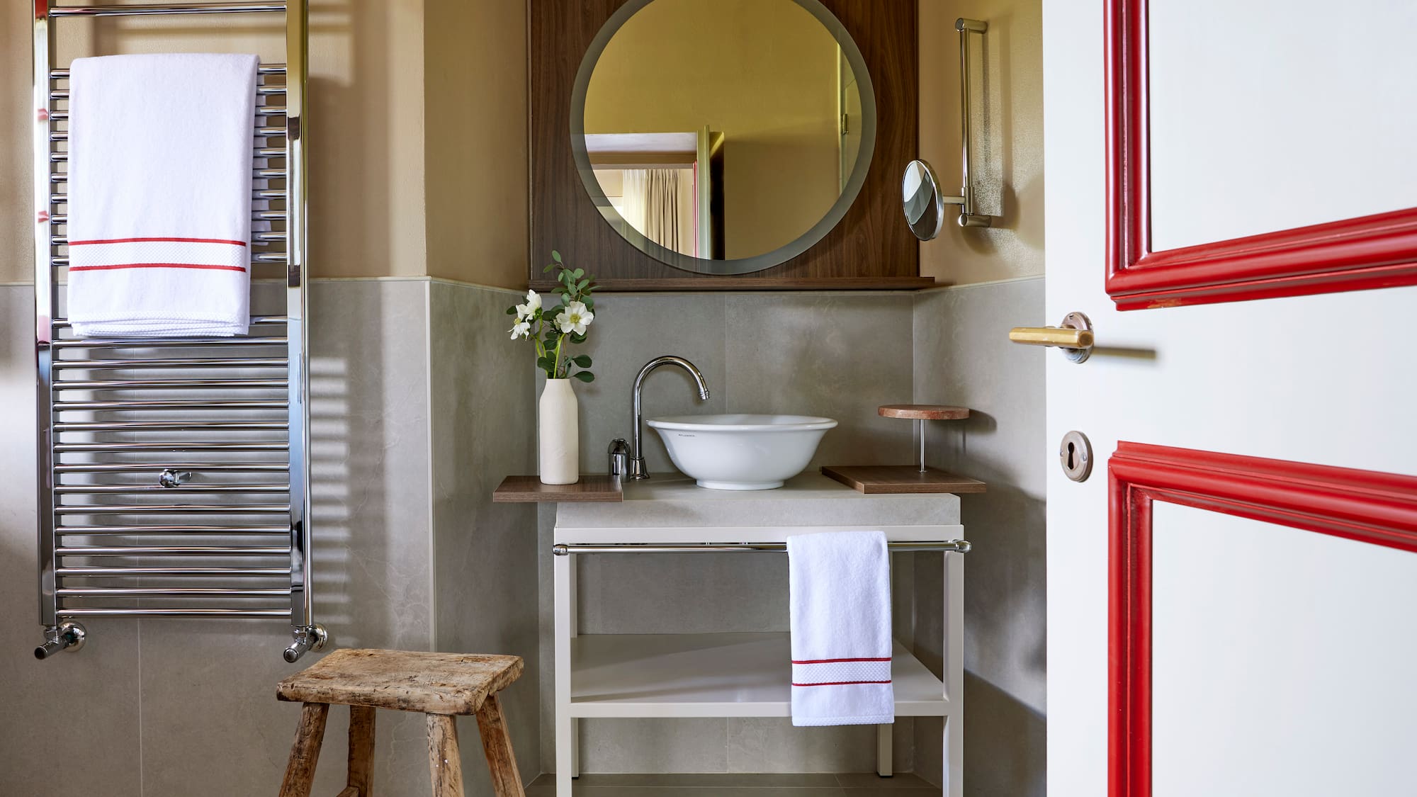 a bathroom with a round mirror and sink