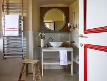 a bathroom with a round mirror and sink