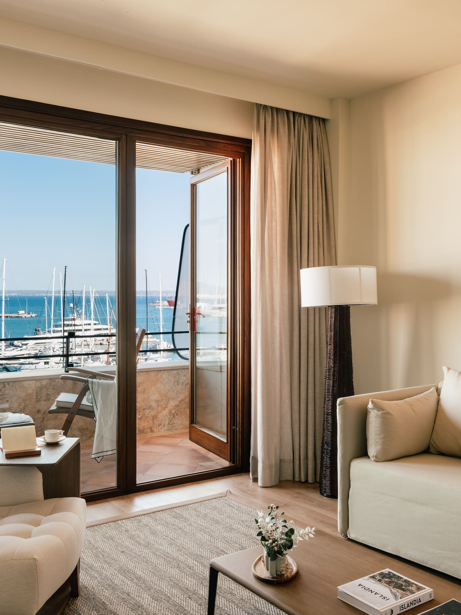 a living room with a view of the water and boats in the background