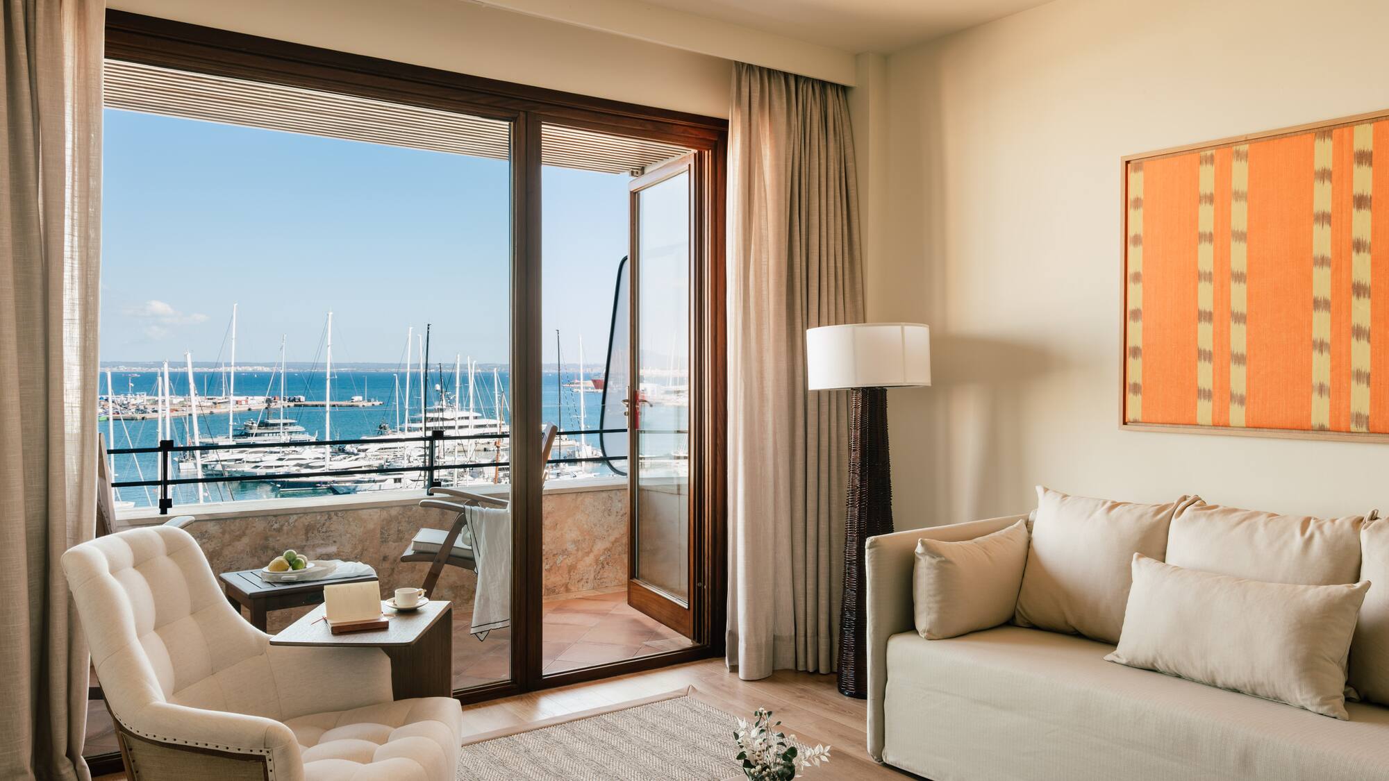 a living room with a view of the water and boats in the background