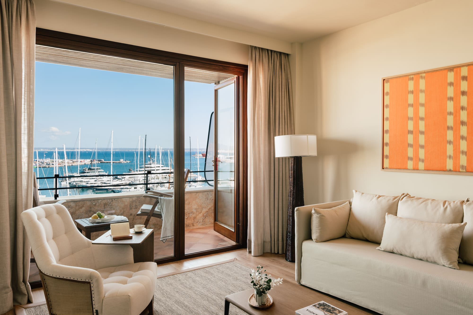 a living room with a view of the water and boats in the background