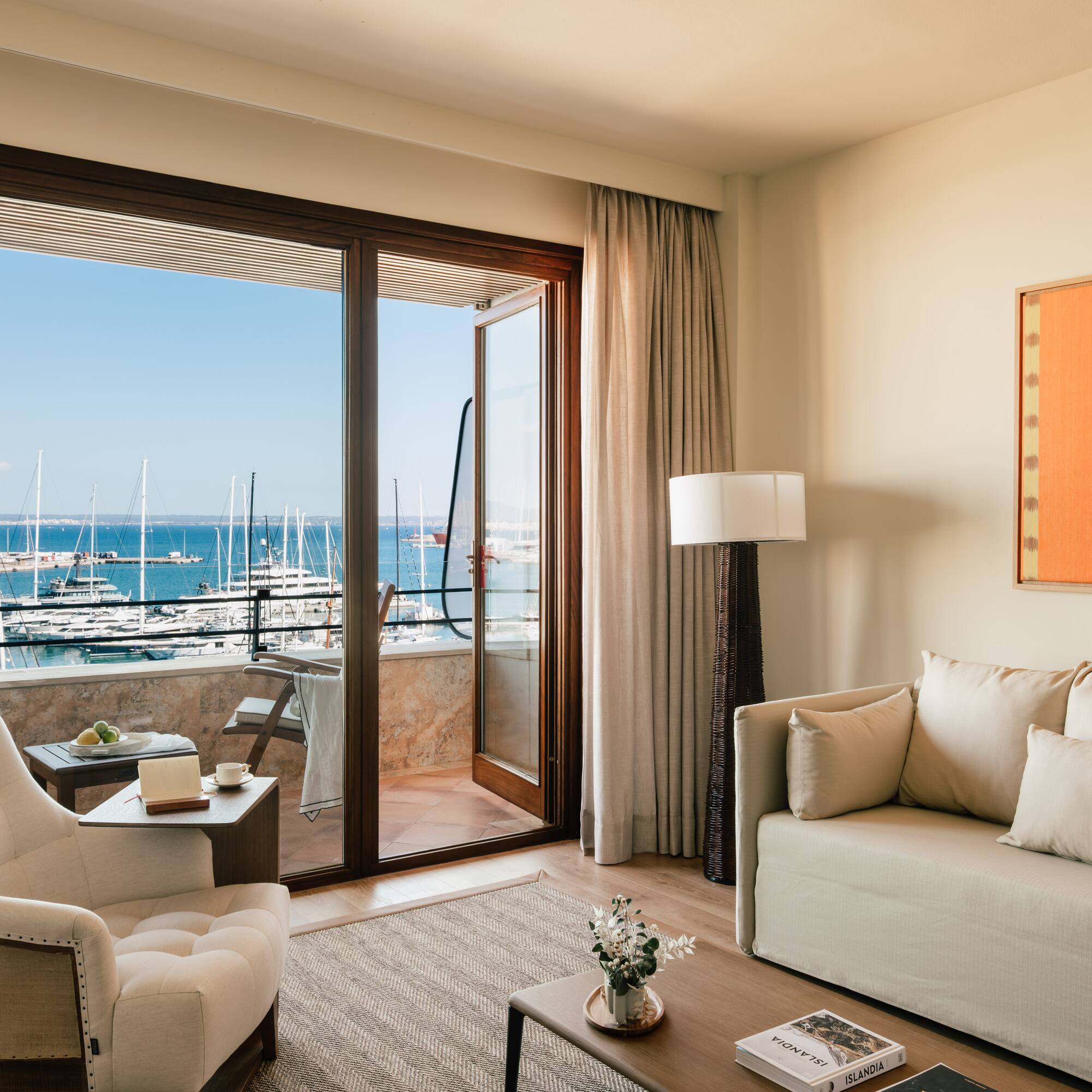 a living room with a view of the water and boats in the background