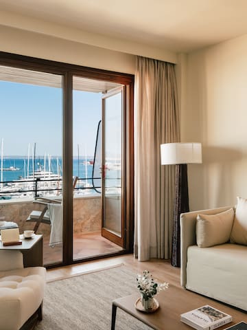 a living room with a view of the water and boats in the background