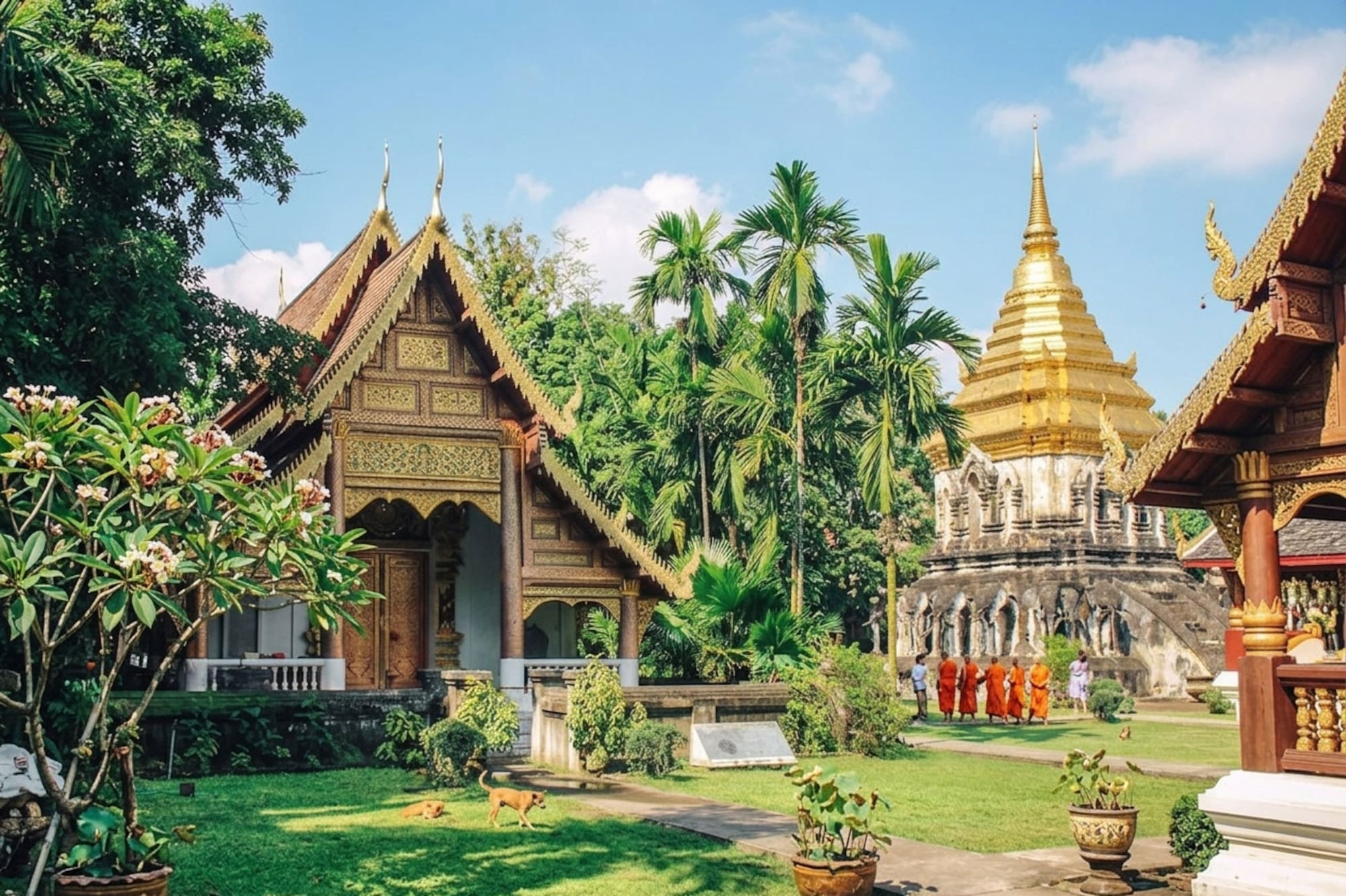 Golden stupa and ornate Thai temple with monks walking in a lush garden.