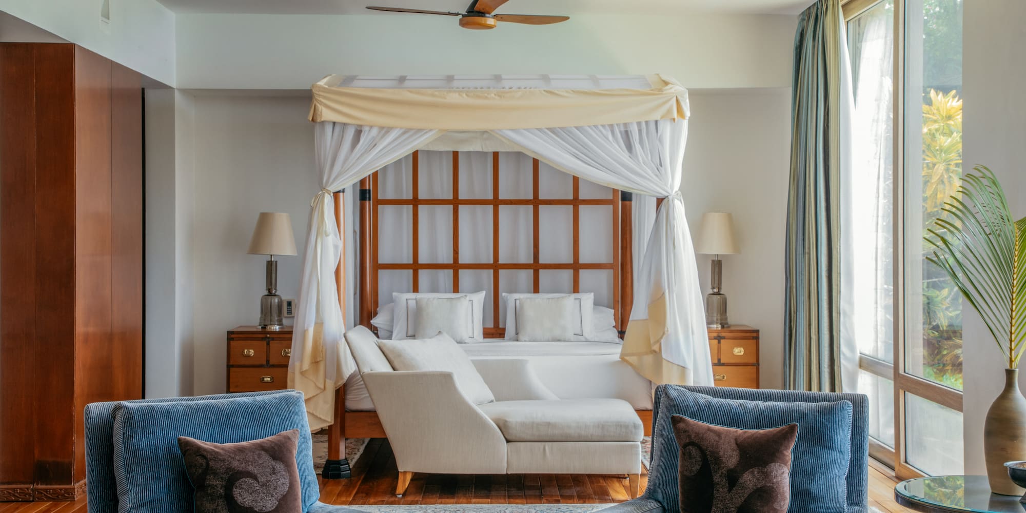 a room with a bed and chairs