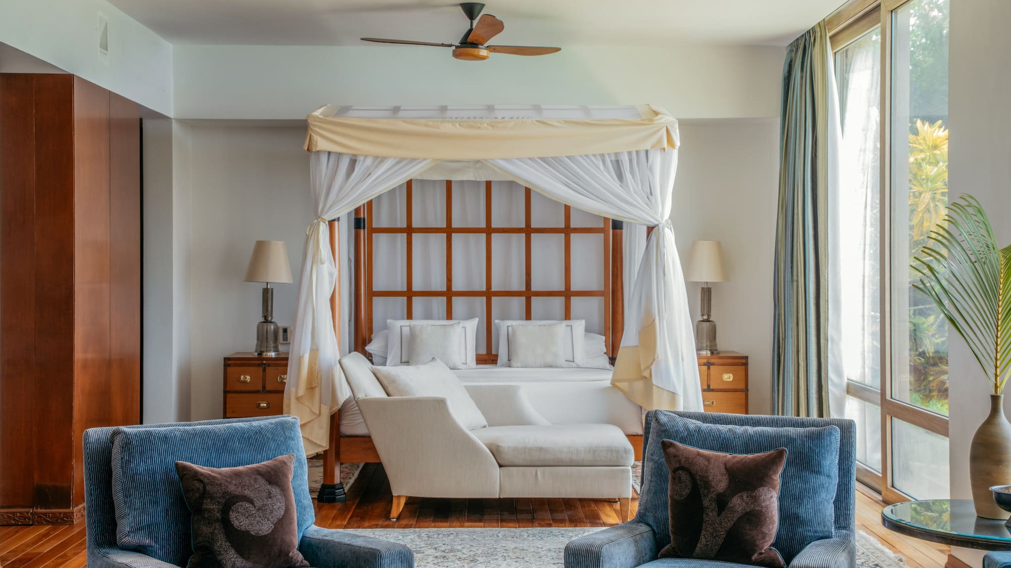 a room with a bed and chairs