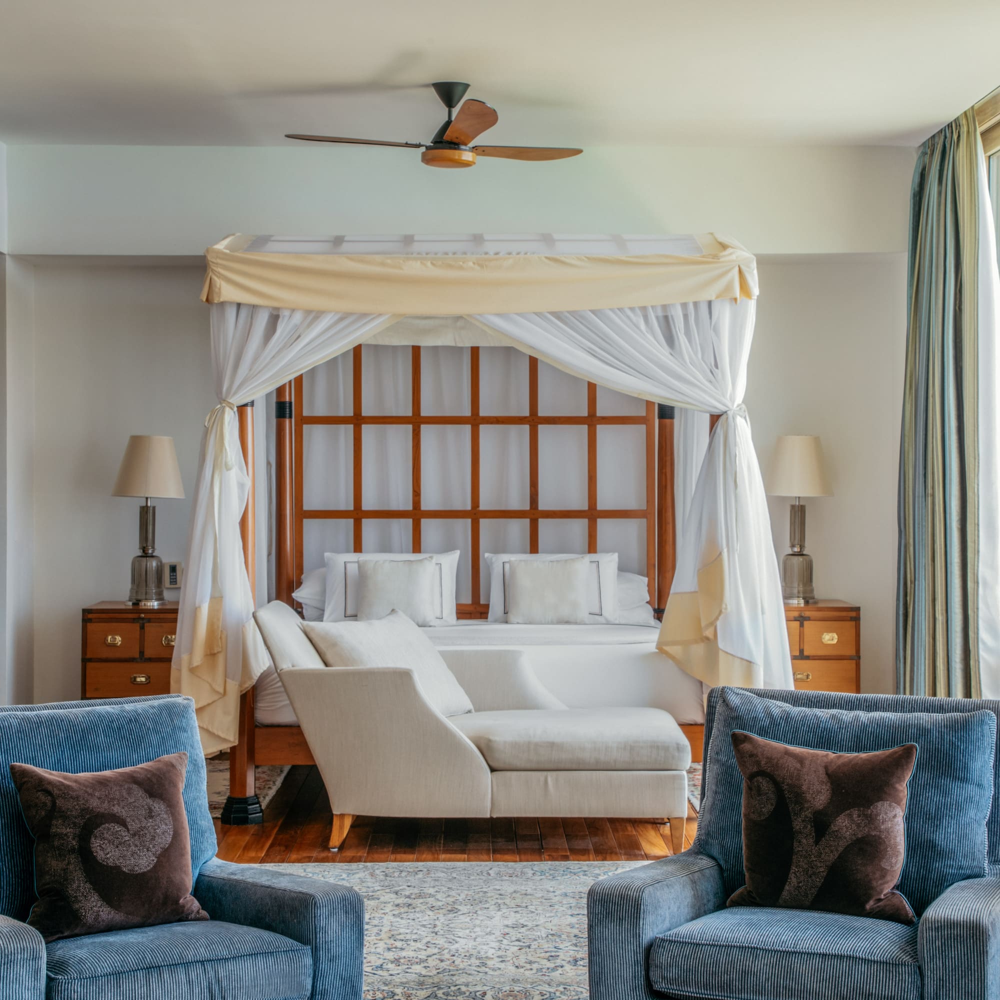 a room with a bed and chairs