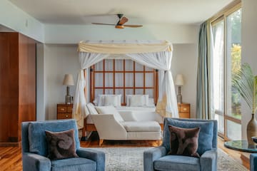 a room with a bed and chairs
