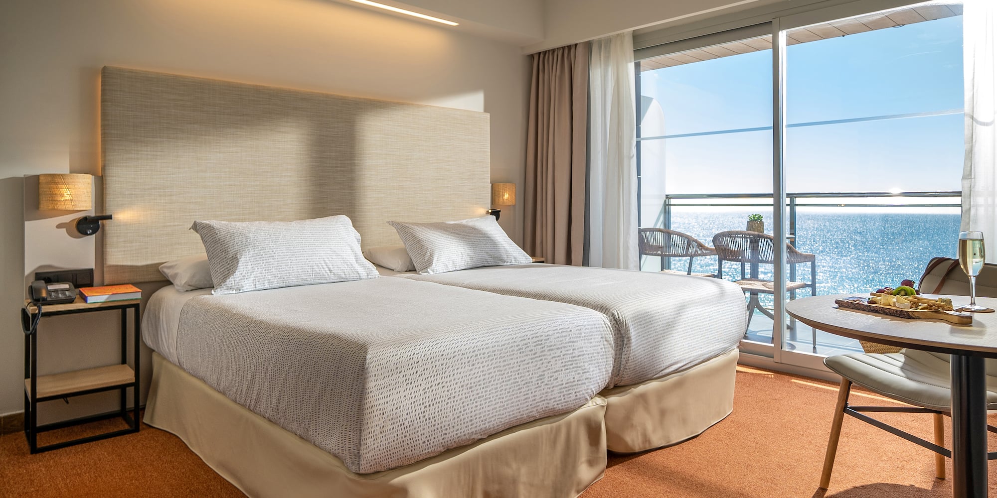 a room with a large bed and a balcony overlooking the ocean