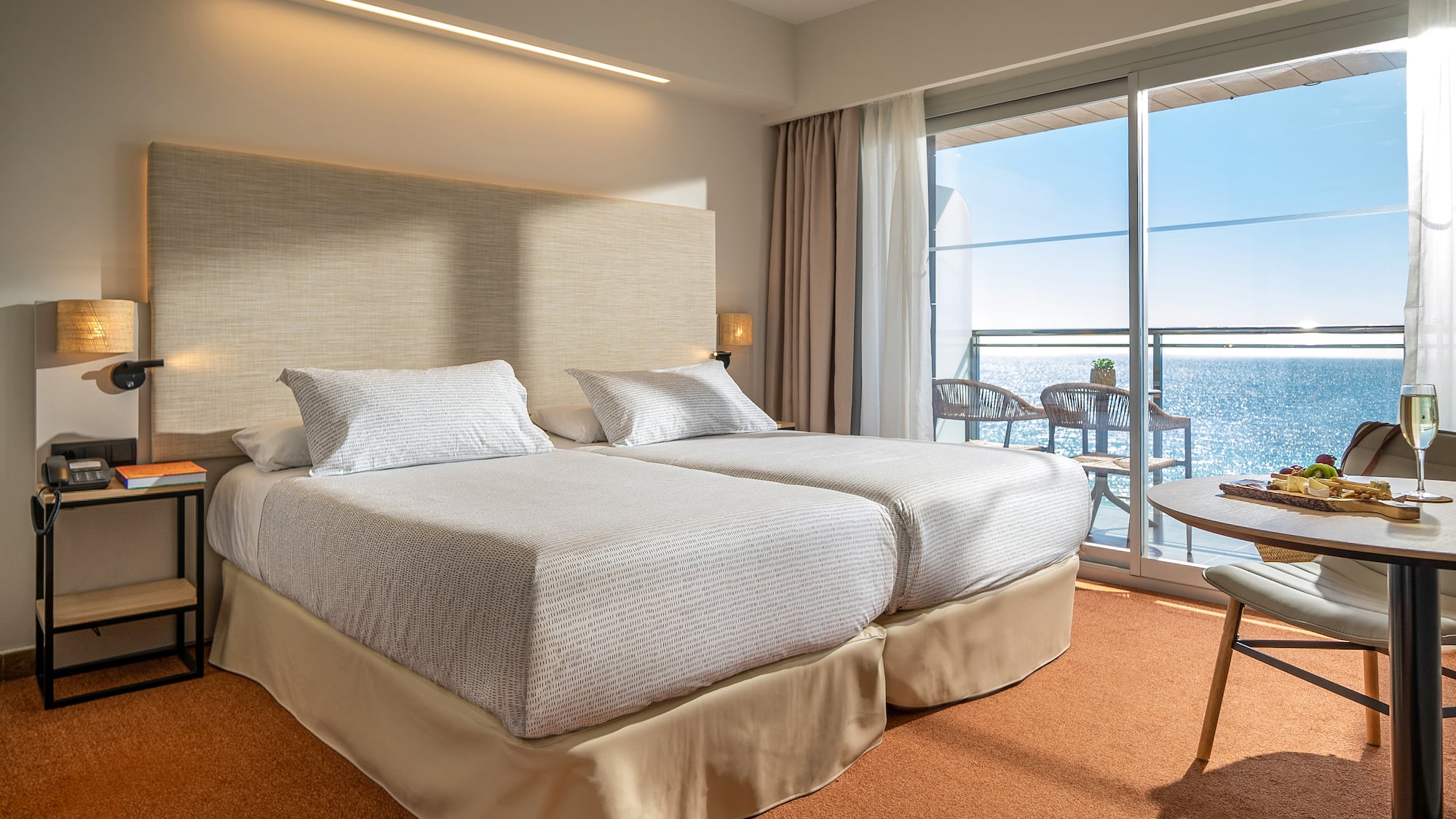 a room with a large bed and a balcony overlooking the ocean