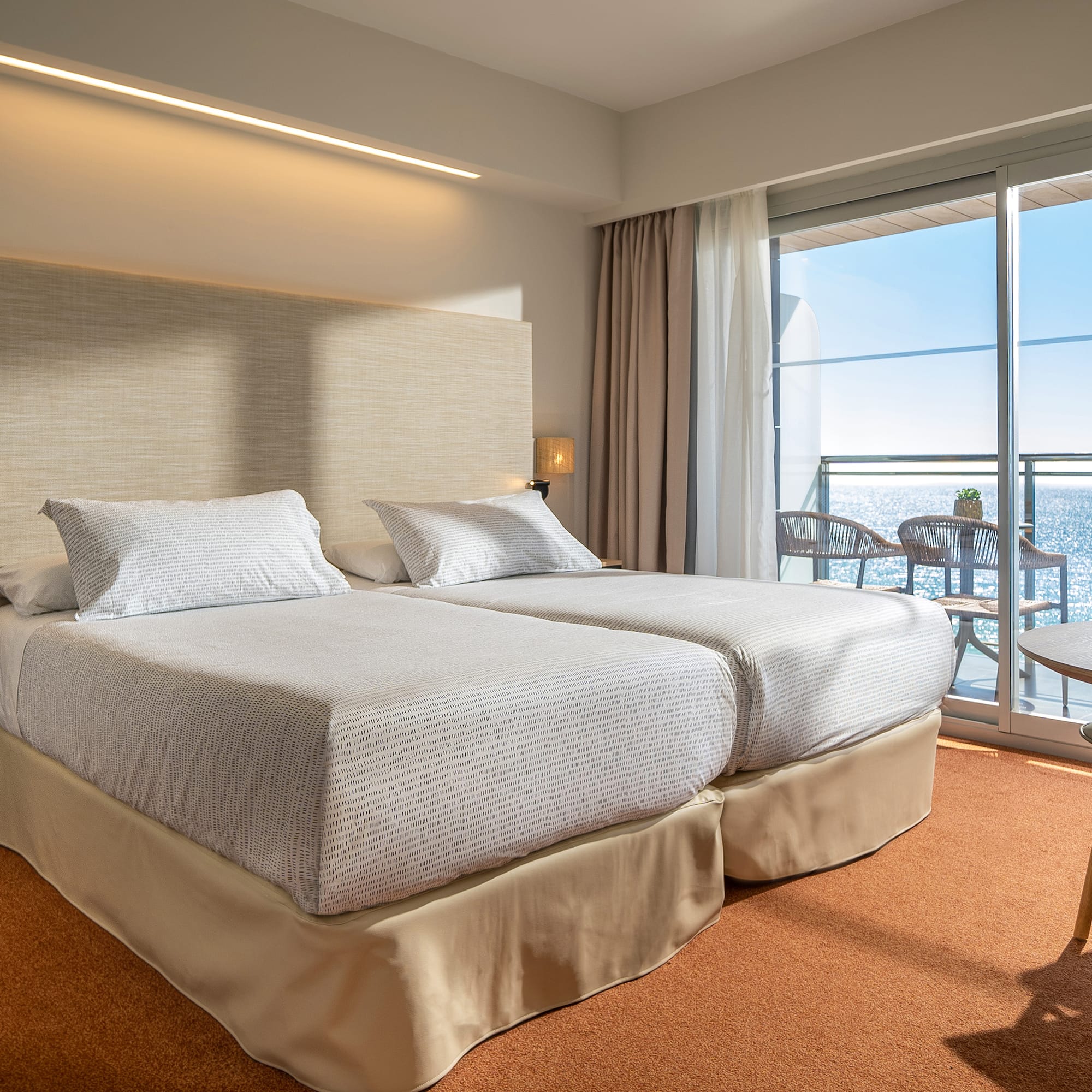 a room with a large bed and a balcony overlooking the ocean