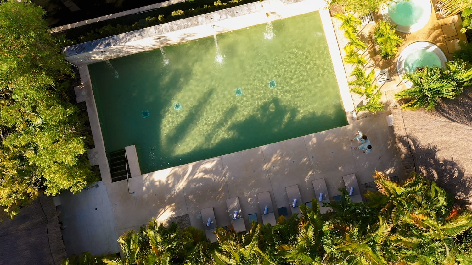 a pool with water jets and trees