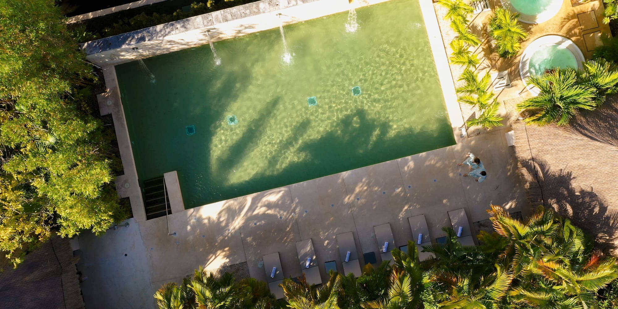 a pool with water jets and trees