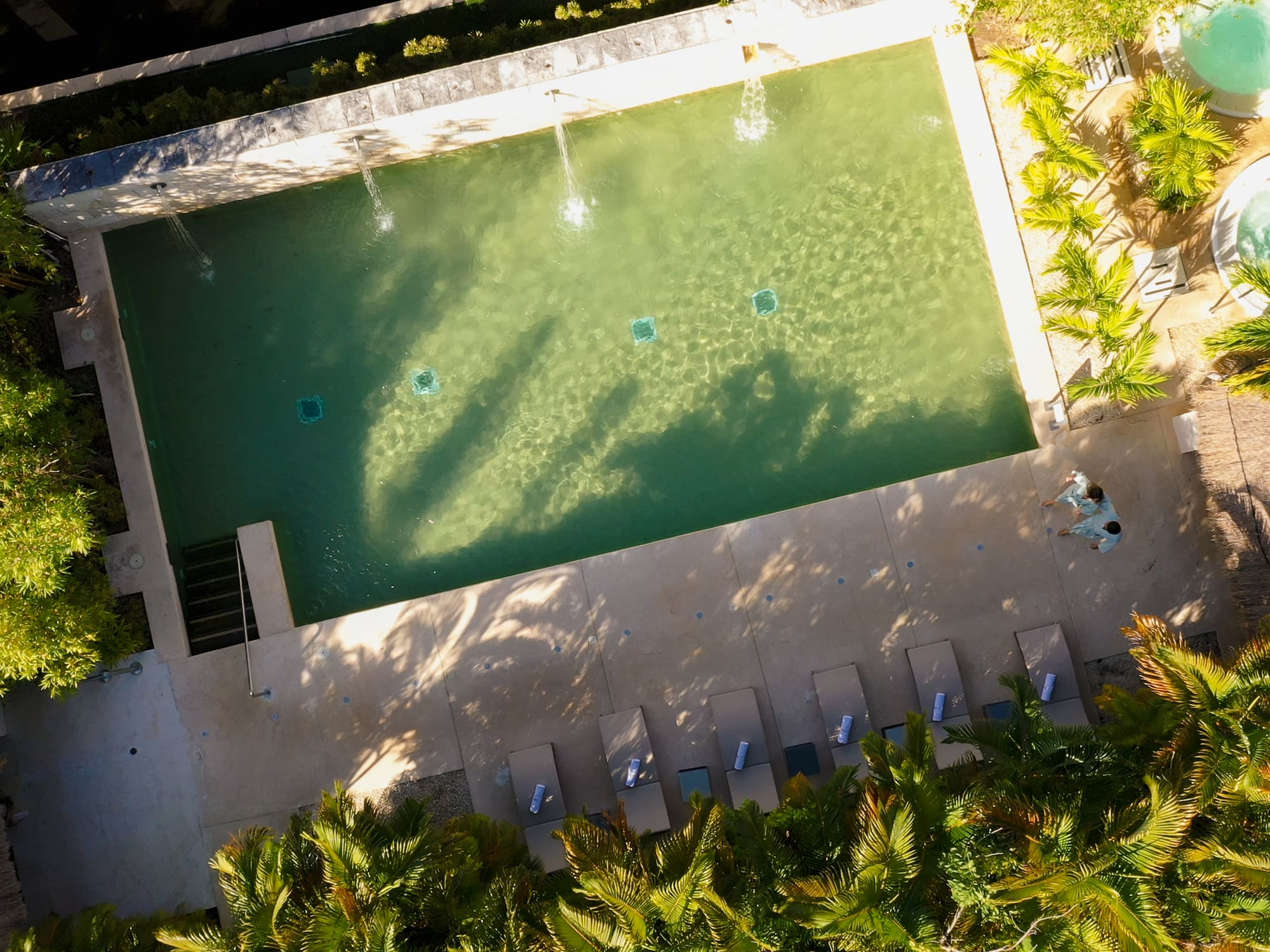 a pool with water jets and trees