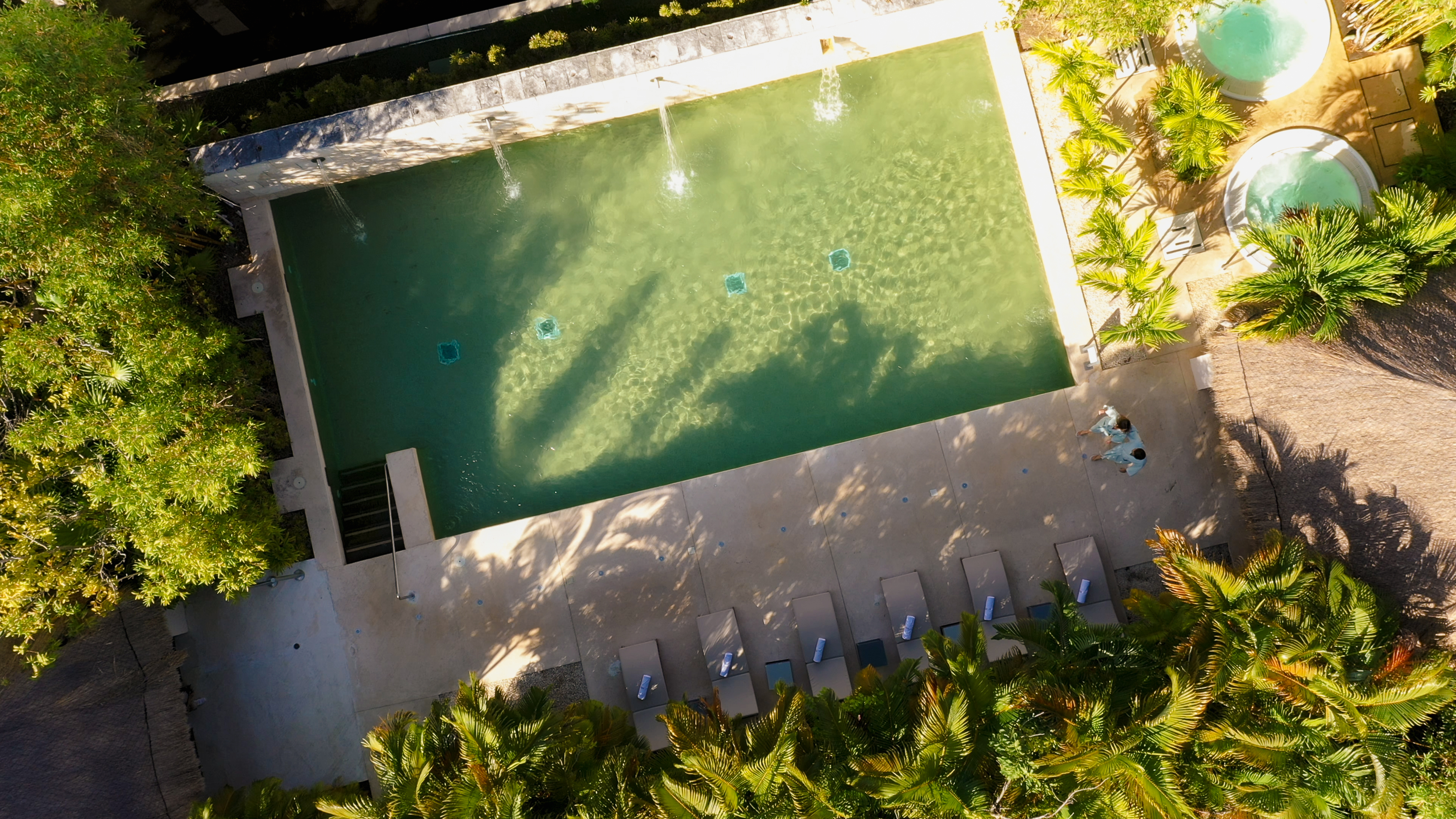a pool with water jets and trees