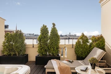 a deck with a chair and a hot tub and trees