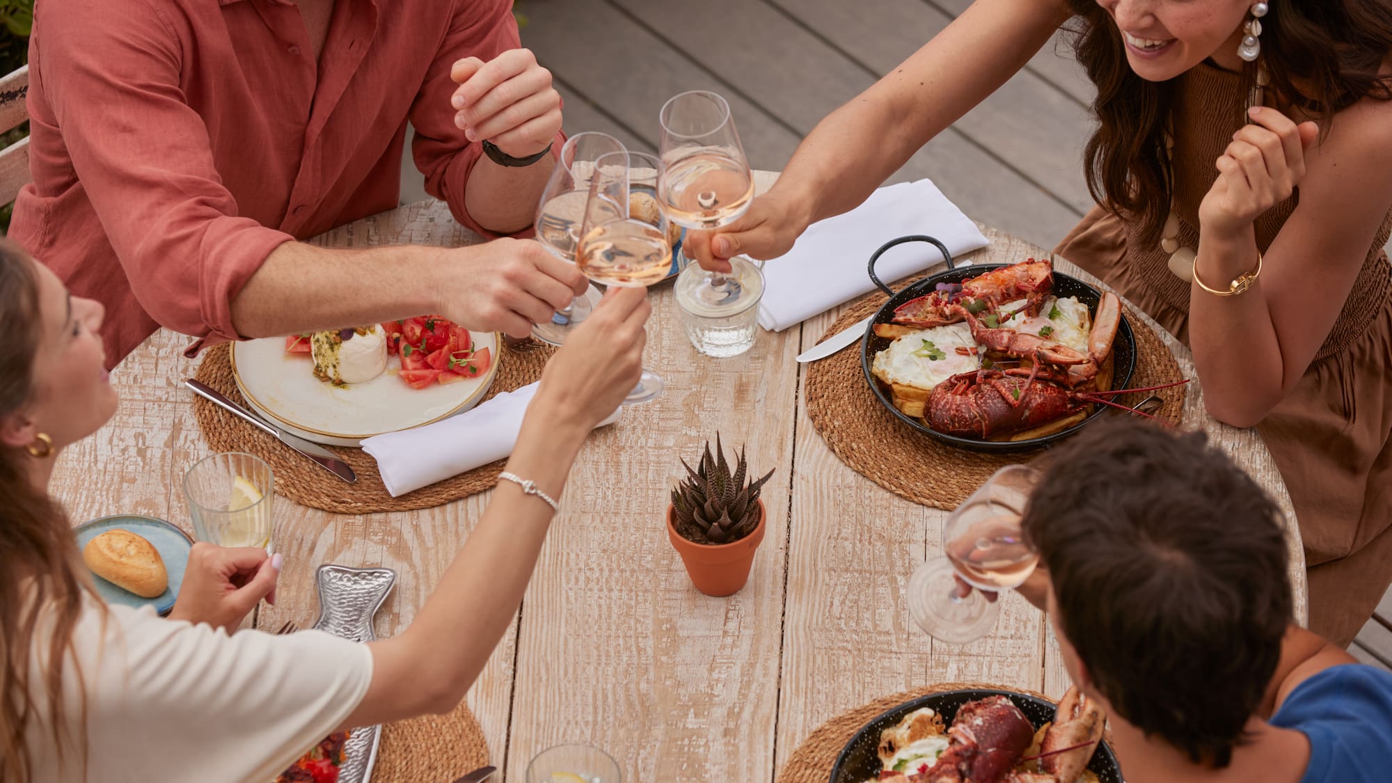 a group of people sitting around a table with food and drinks