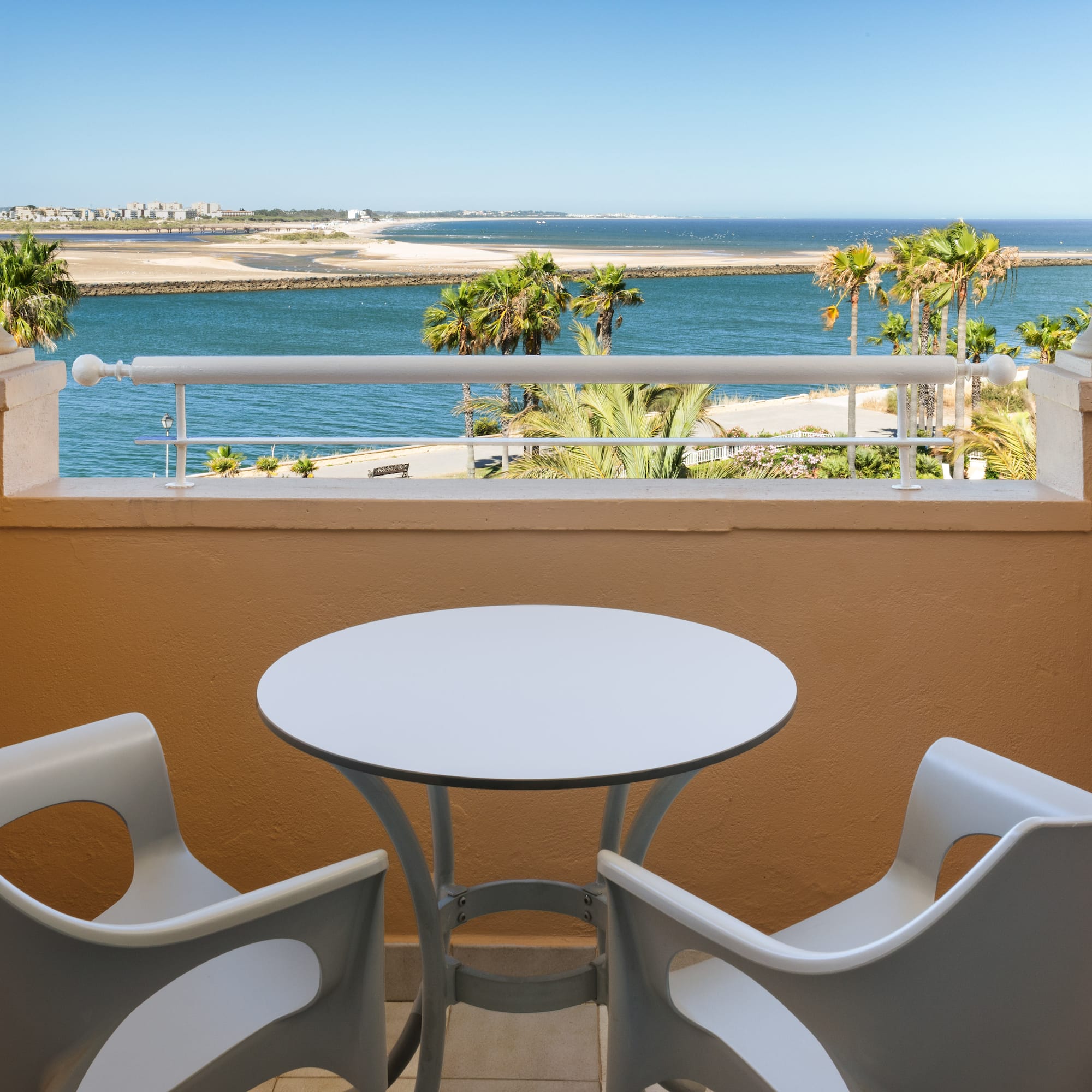 a table and chairs on a balcony overlooking a body of water
