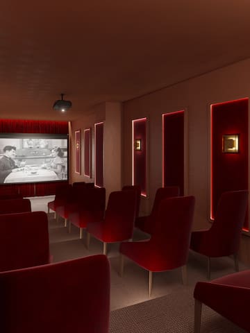 a room with red chairs and a projector screen
