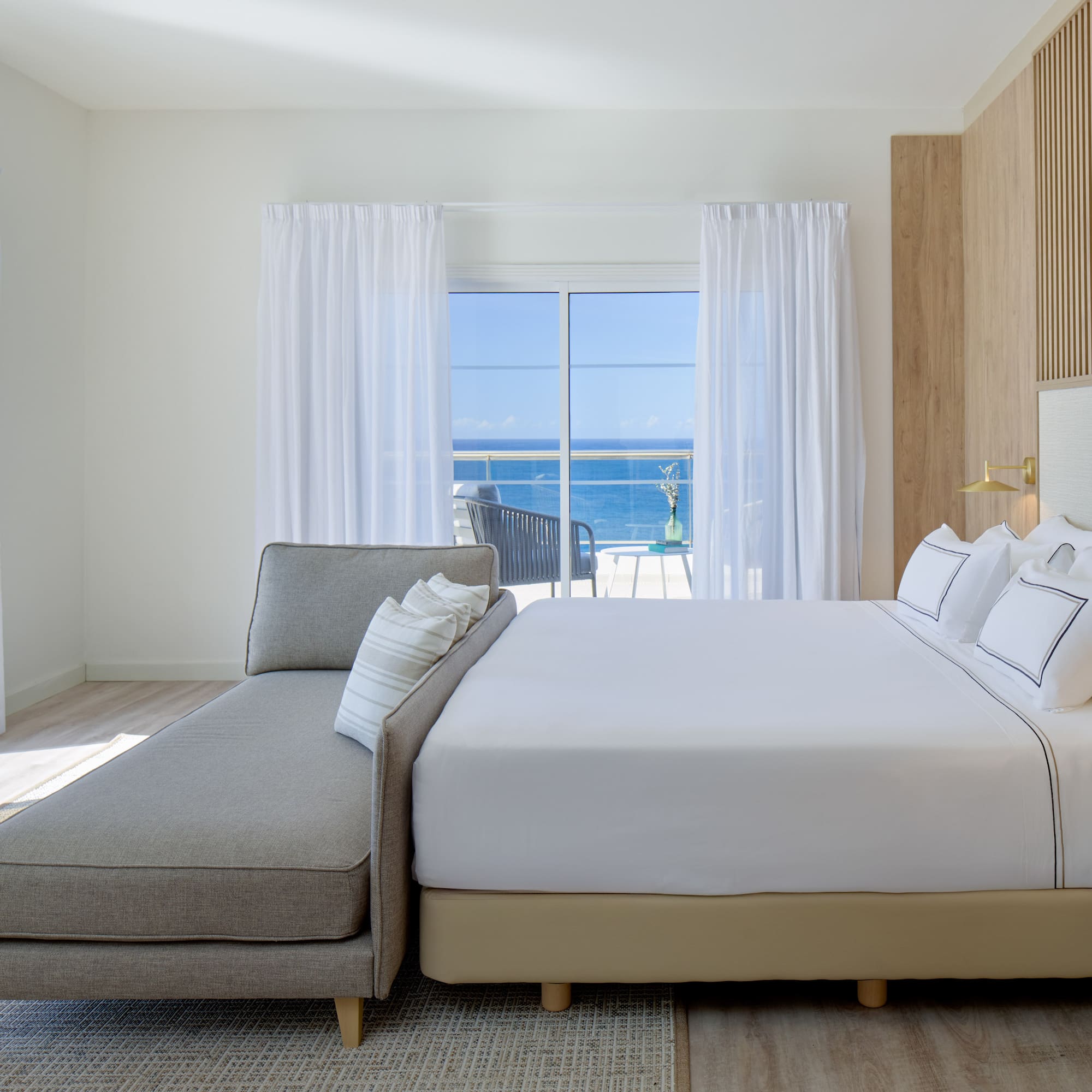 a bed in a room with a couch and a window