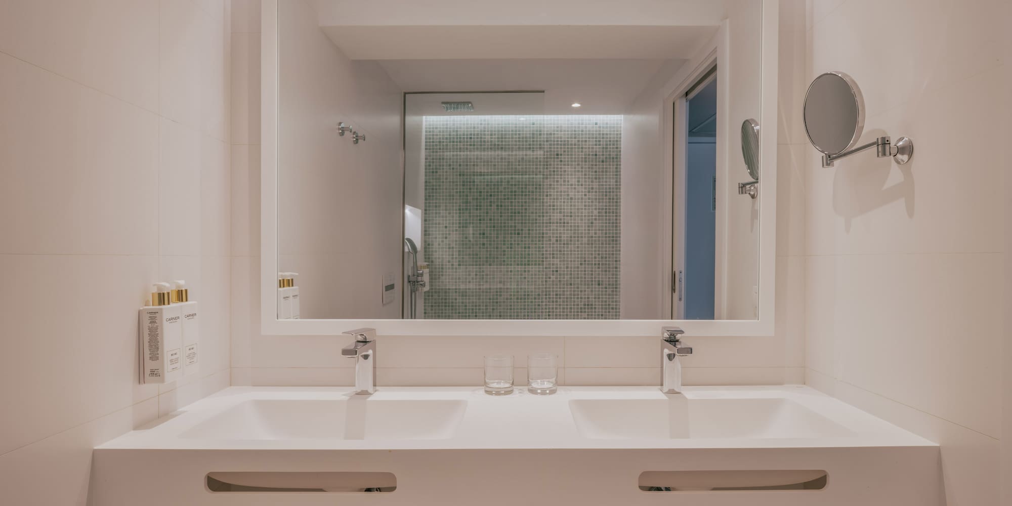 Modern bathroom: double vanity, large mirror, green mosaic shower.
