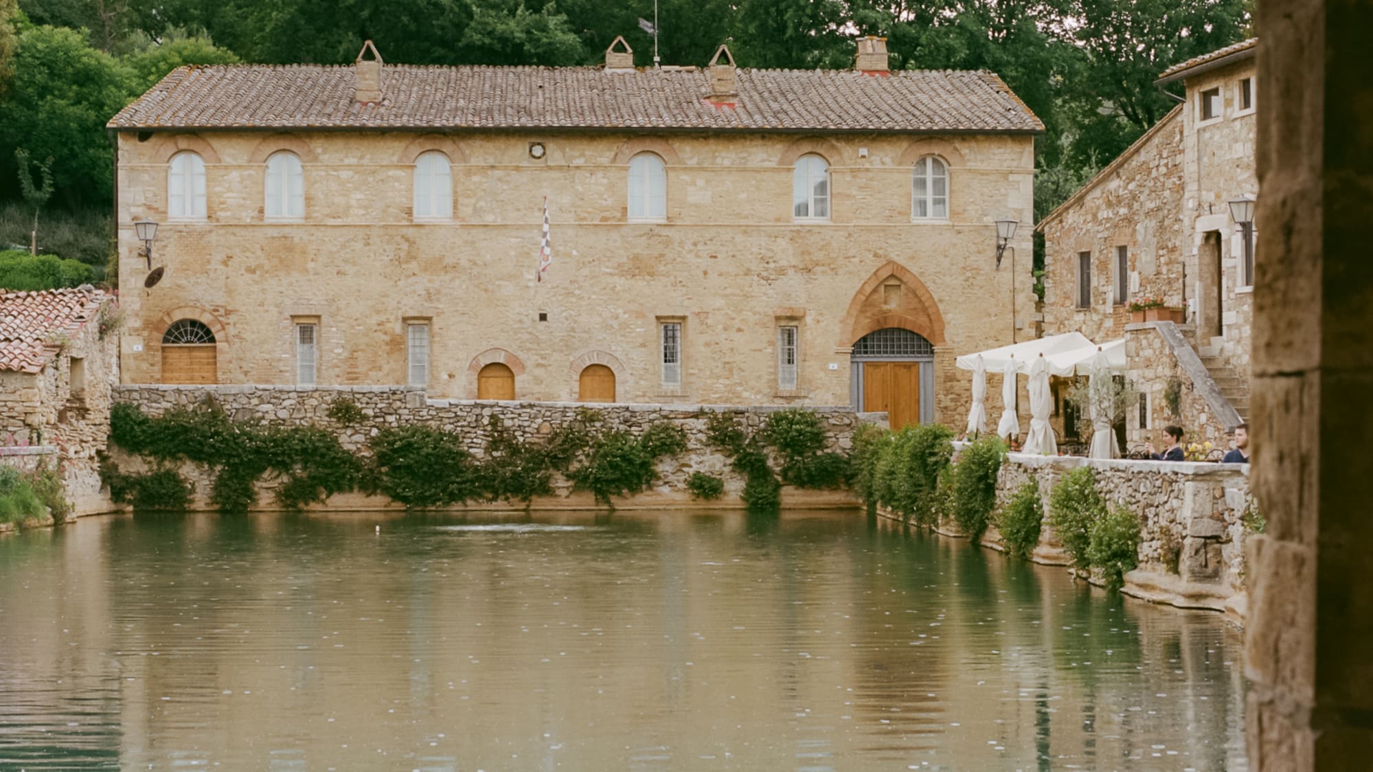 a pool of water with a stone building in the background